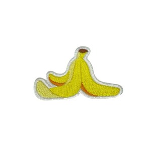 May include: Embroidered patch featuring a yellow banana peel with a brown tip and a white border. The patch has a textured appearance, suggesting it is made of fabric and thread. The design is simple and cartoon-like.