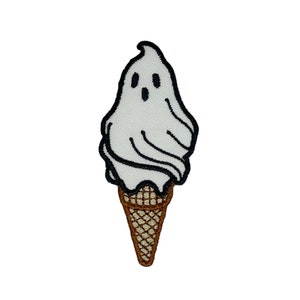 May include: A white ghost-shaped ice cream cone with a brown waffle cone.