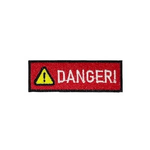 May include: A rectangular red patch with the word "DANGER!" in white capital letters. A yellow triangle with an exclamation mark is on the left. The patch has a black border.