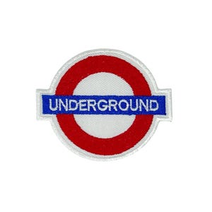 May include: Embroidered patch of the London Underground logo. The design features a red circle with a white centre, a blue rectangular bar with the word "UNDERGROUND" in white, and a white border.