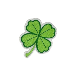 May include: A green four-leaf clover embroidered patch with white stitching around the edges.