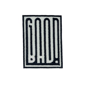 Pode incluir: Etiqueta bordada em preto e branco com a palavra "GOOD" em uma fonte estilizada.