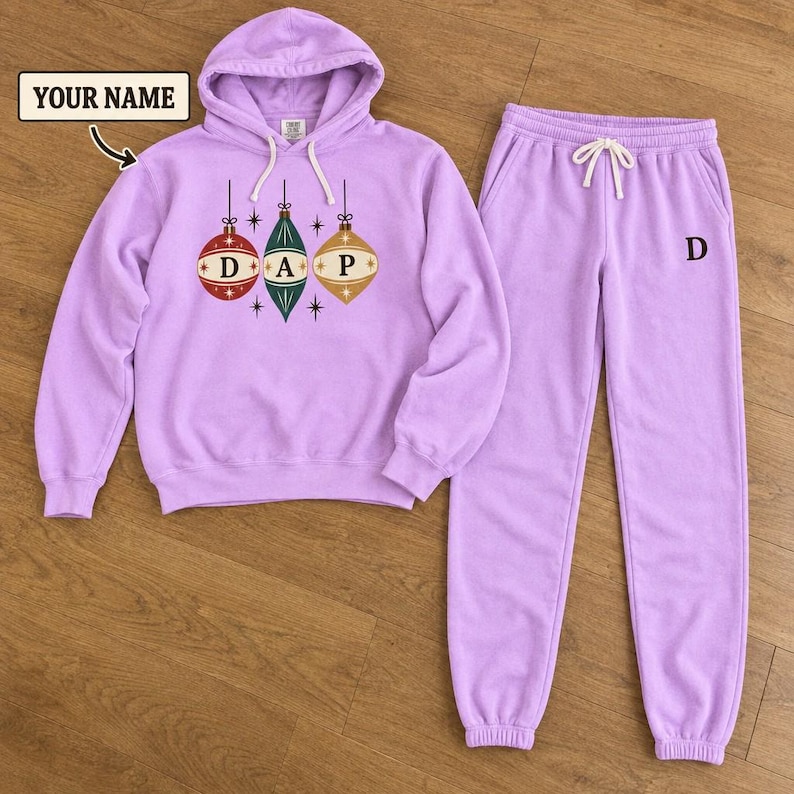 Lavender hoodie and joggers with three retro ornaments bearing D, A and P initials.