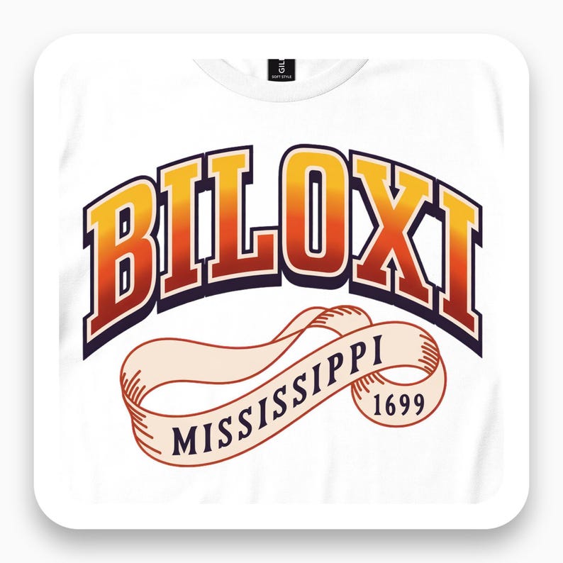 Framed close view of white T-shirt with gold-to-red Biloxi varsity lettering above a Mississippi 1699 ribbon.