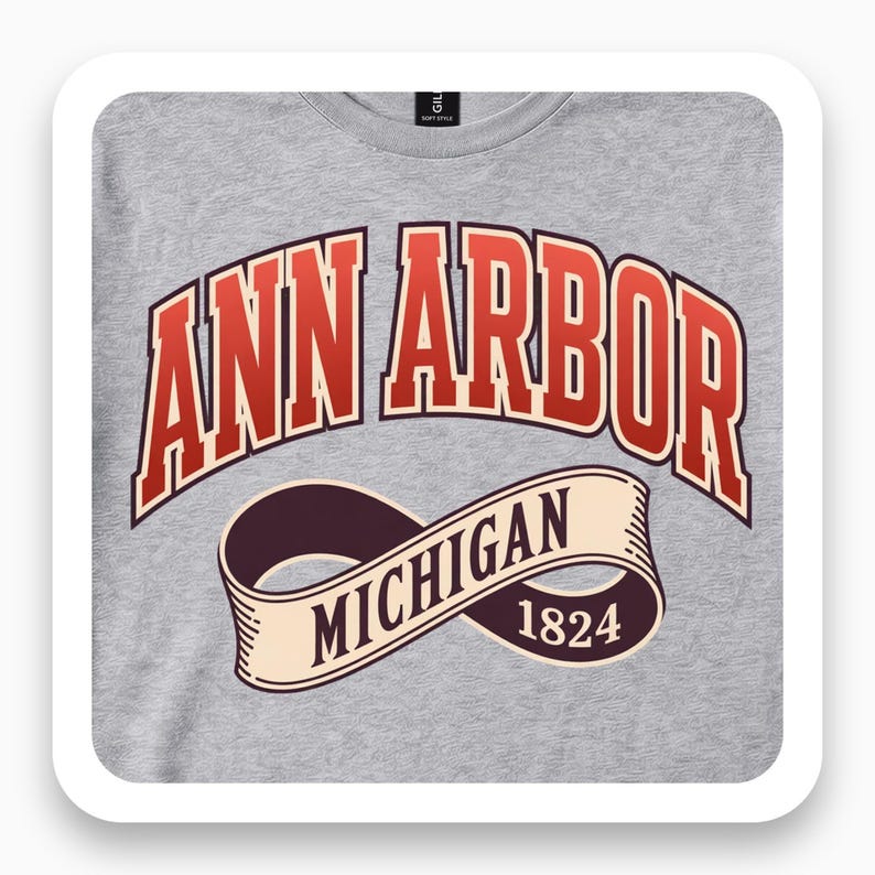 Close view of a gray shirt with red Ann Arbor varsity lettering and a Michigan 1824 ribbon