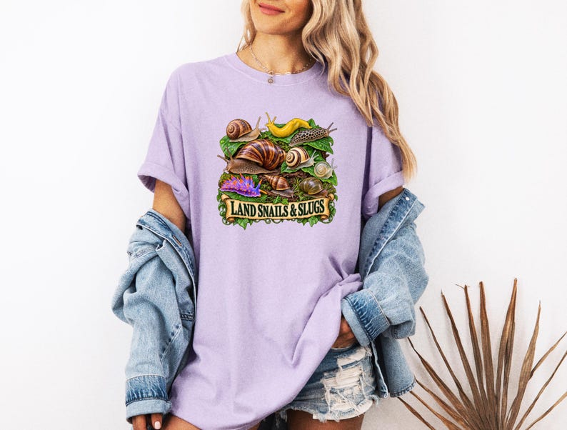 Lavender tee with snails, slugs and foliage, worn with a denim jacket.