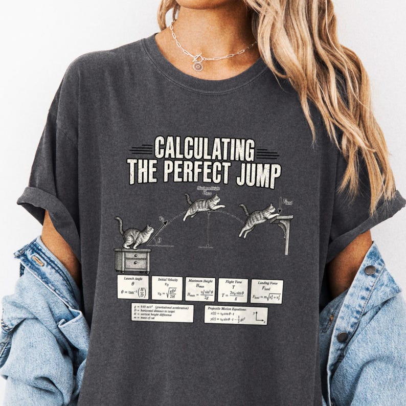 Close view of charcoal T-shirt on a model with Calculating the Perfect Jump text above cat motion diagrams and equations.