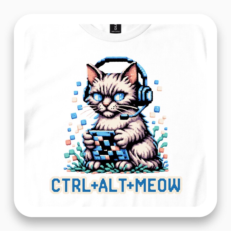 Framed close view of a white T-shirt with a pixel-style cat wearing a gaming headset above Ctrl+Alt+Meow text.
