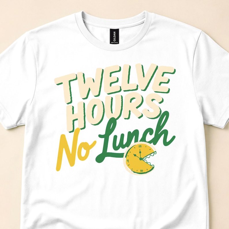 Close-up of a white T-shirt with cream, green and yellow "Twelve Hours No Lunch" text and a yellow clock with a jagged mouth.