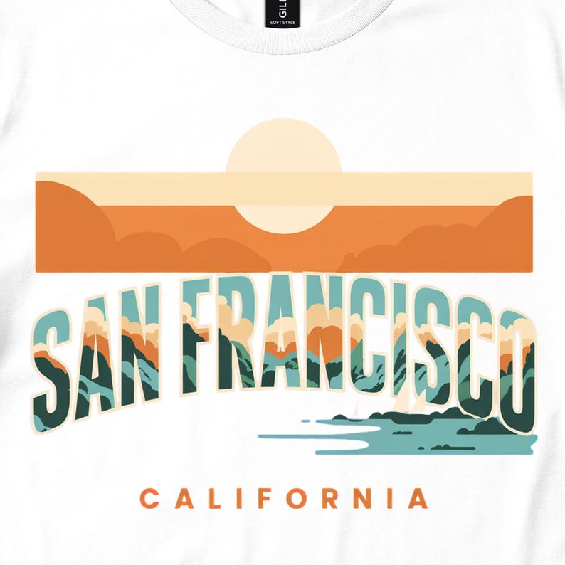Close view of a white tee with San Francisco lettering, an orange sunset and teal shoreline.