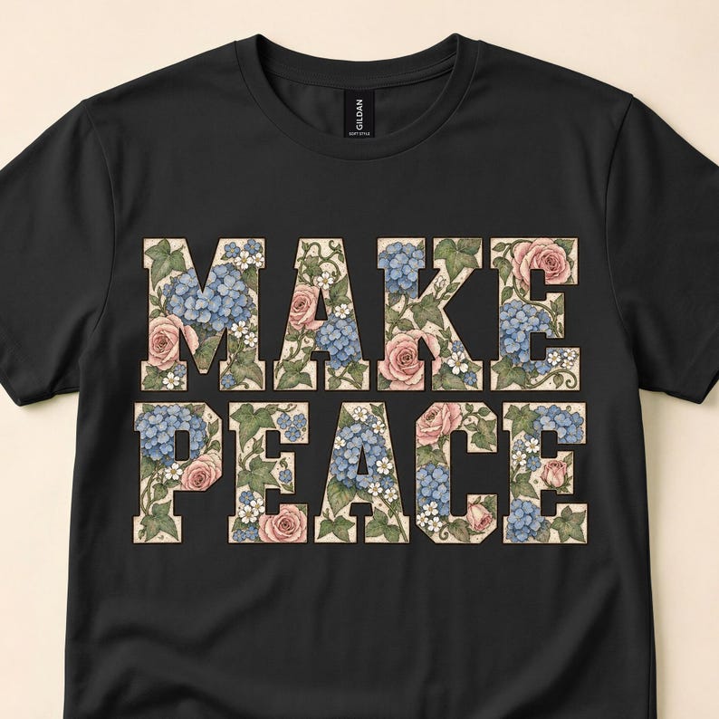 Close view of a black T-shirt with large Make Peace letters filled with pink and blue flowers.