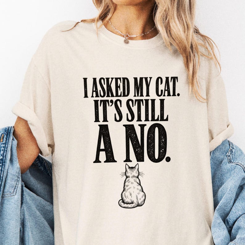 Cream tee detail with I Asked My Cat, It's Still a No text above a small cat seen from behind.