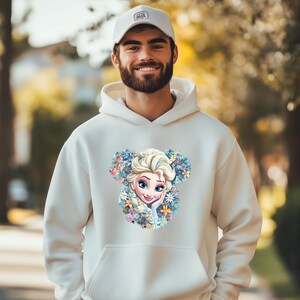 a man wearing a white hoodie with a picture of a frozen princess on it