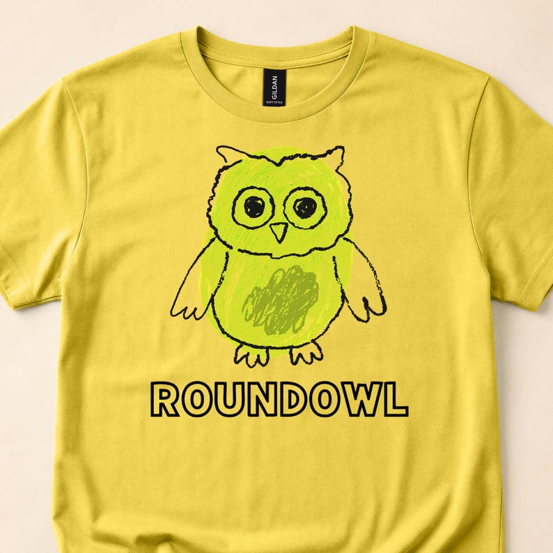 Close view of a yellow T-shirt with a green owl doodle and Roundowl text.