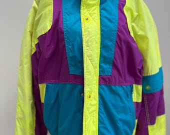 May include: A vintage ski jacket with a bright yellow, purple and teal colour block design. The jacket has a high collar and a zip closure.