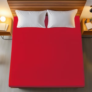 May include: A red fitted sheet for a bed. The sheet is made of a soft, comfortable material and is perfect for a bedroom.