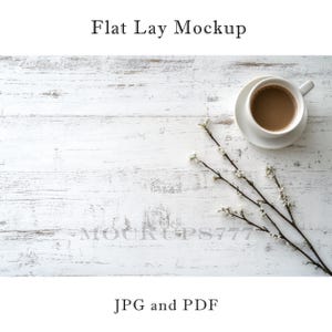 Może przedstawiać: Makieta flat lay z białą filiżanką kawy na białym spodeczku, gałązką białych kwiatów i białym drewnianym tłem.