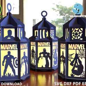May include: Three navy blue paper lanterns featuring Marvel superhero silhouettes and the Marvel logo. The lanterns are hexagonal with a handle. Text includes "DIGITAL DOWNLOAD" and "SVG DXF PDF EPS CDR".