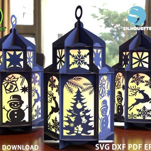 May include: Three navy blue paper lanterns with cut-out holiday designs, including snowflakes, a snowman, and a Christmas tree. The lanterns are illuminated from within, creating a warm glow. Text on the image reads "DIGITAL DOWNLOAD" and "SVG DXF PDF EPS CDR".