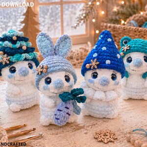 May include: Four crocheted plush figures in white and blue tones. One wears a tiered tree hat, one a bunny ear hat holding a carrot, one a blue pointed hat with white dots, and one a teal frog hat. Each has large dark eyes and a soft texture.