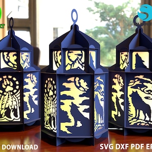 May include: Three blue paper lanterns with intricate cut-out designs featuring wolves, mountains, and a full moon. The lanterns are illuminated from within, creating a warm glow.  The text "DIGITAL DOWNLOAD" and "SVG DXF PDF EPS CDR" are visible at the bottom of the image.