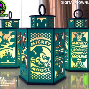 May include: Three teal lanterns with black detailing, showcasing Mickey Mouse designs and cut-out silhouettes. Each lantern has a handle and is lit from inside. The image also includes the text "DIGITAL DOWNLOAD" and "STL".