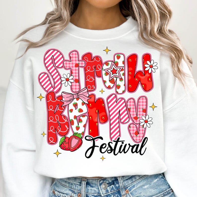 May include: White sweatshirt with a pink and red graphic design that says "Strawberry Festival". The graphic features strawberries, stars, and flowers.
