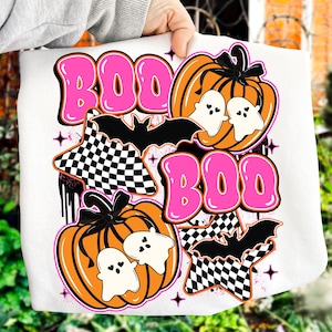 Puede incluir: Sudadera blanca con tem&aacute;tica de Halloween con la palabra "BOO" en letras rosas. El dise&ntilde;o incluye calabazas naranjas, fantasmas blancos, murci&eacute;lagos negros y estrellas a cuadros. Un gr&aacute;fico de Halloween divertido y festivo.