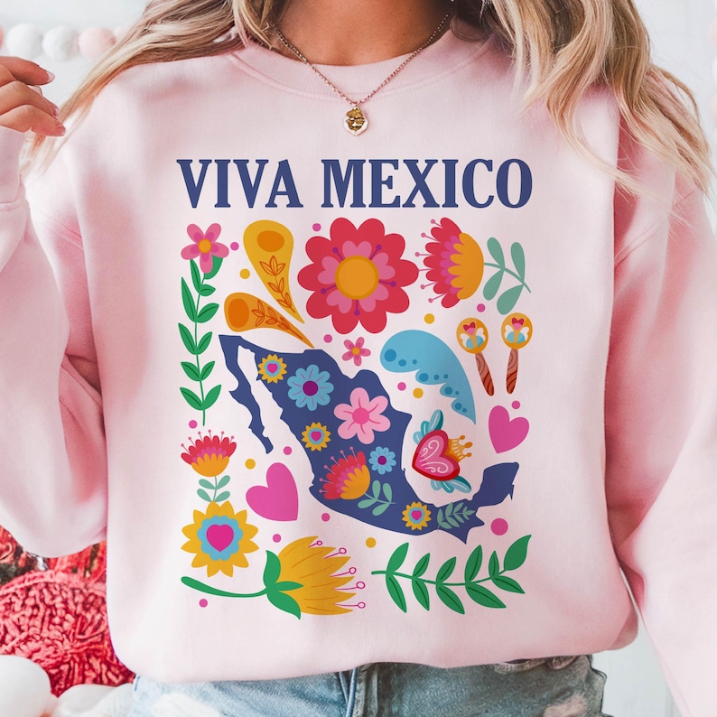 May include: Pink sweatshirt with a blue outline of Mexico and colorful floral designs. The text "VIVA MEXICO" is printed in blue on the front.