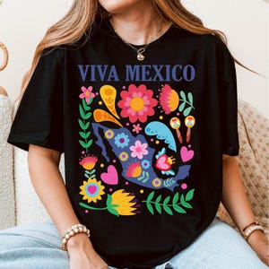 May include: Black t-shirt with a colorful floral design featuring a silhouette of Mexico and the text "Viva Mexico".