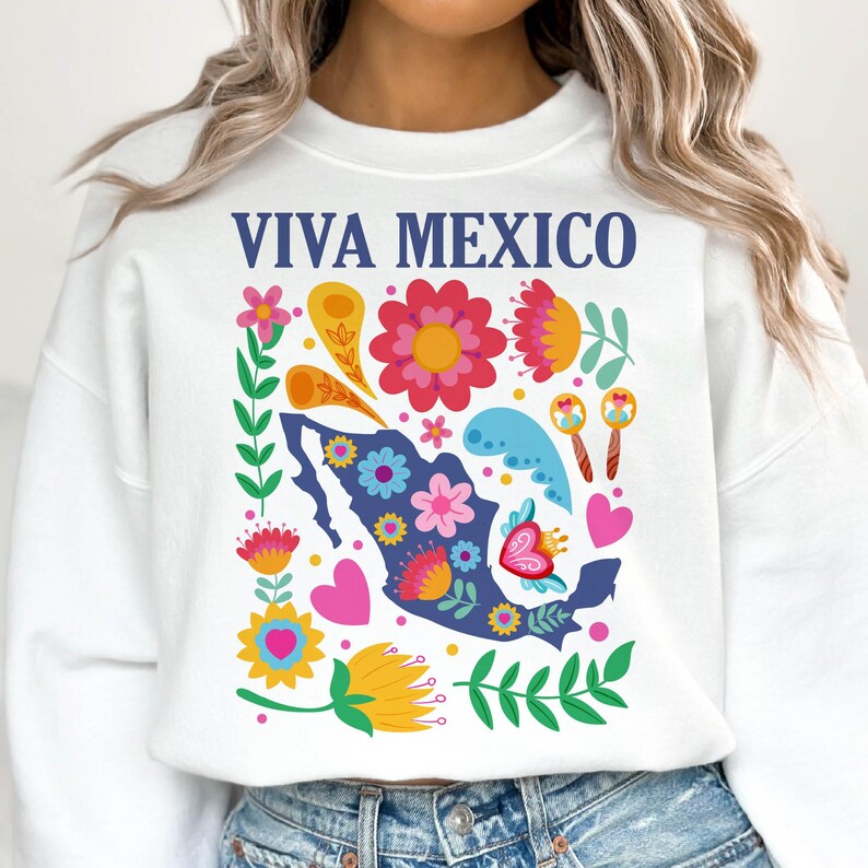 May include: White sweatshirt with a blue outline of Mexico and colorful flowers, hearts, and swirls. The text "VIVA MEXICO" is printed in blue on the front.