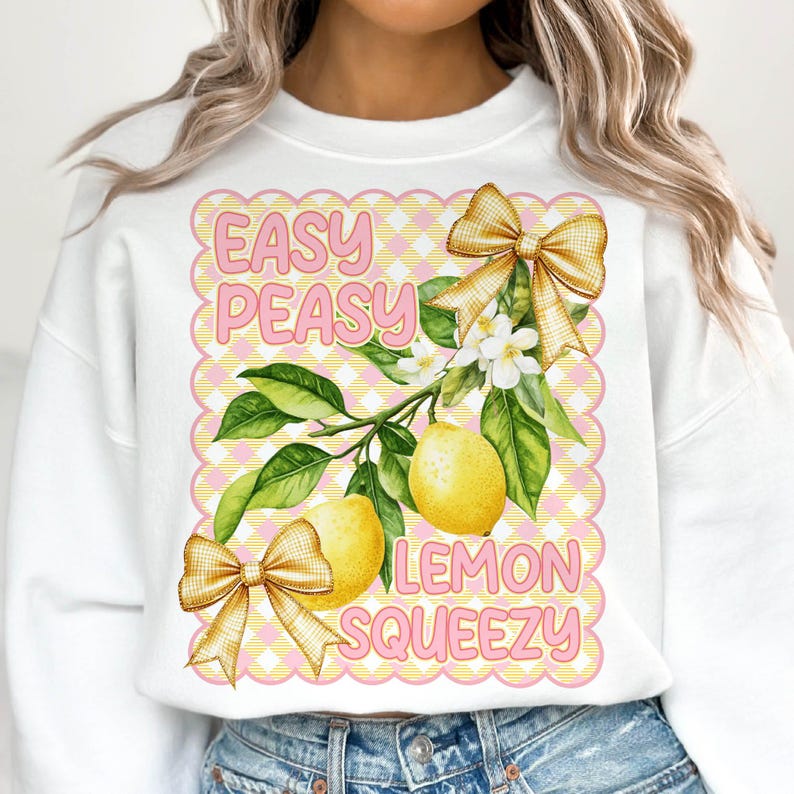 Pu&ograve; includere: Felpa bianca con un design a scacchi rosa e giallo. Il design presenta un albero di limone con limoni, fiori e fiocchi. Il testo "Easy Peasy Lemon Squeezy" &egrave; scritto in rosa.
