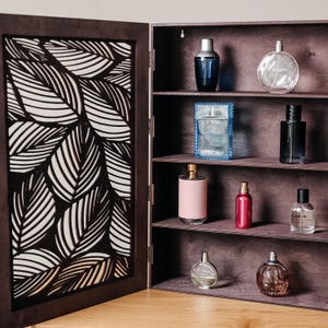 May include: A dark brown wooden cabinet with a patterned door and four shelves. The shelves are filled with various glass bottles of perfume and cologne.
