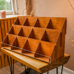 May include: A wooden display stand with multiple shelves, perfect for showcasing small items. The stand is made of natural wood and has a rustic, farmhouse style.