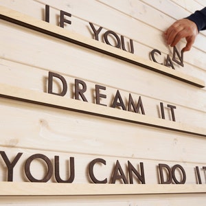 May include: Wooden wall decor with the phrase "If you can dream it, you can do it" in brown letters.