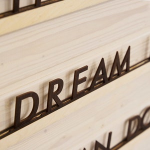 May include: Wooden wall decor with the words "DREAM IT" and "DO IT" in black letters.