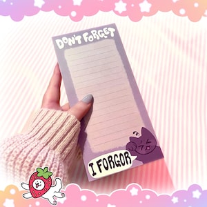 May include: A rectangular purple notepad with lined paper, held by a person. The notepad has the words "DON'T FORGET" at the top and "I FORGOR" in a speech bubble at the bottom. A cartoon cat is on the right side.