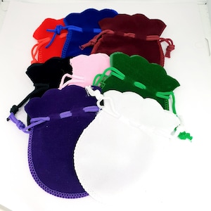 Puede incluir: Surtido de diez bolsitas de terciopelo con cordón de ajuste en varios colores, incluyendo rojo, azul, verde, blanco, negro y rosa. Las bolsitas están hechas de terciopelo suave y lujoso y tienen un borde festoneado.