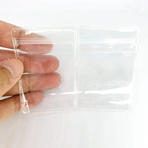 10個/パック 40 mm*60 mm 透明 PVC 取り外し可能なリングペンダントチャームジュエリー抗酸化包装バッグ 小型製品ディスプレイギフトバッグ用