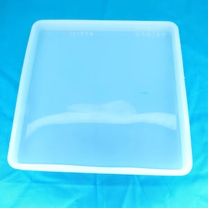 May include: A clear, square silicone mold for resin casting. The mold is made of flexible silicone and has a smooth, glossy finish.