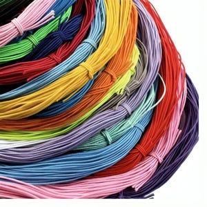 May include: A selection of brightly coloured elastic cords in shades of pink, green, blue, yellow, and red. Each bundle is tied with a matching cord, creating a vibrant display. These cords are suitable for crafting and jewellery making.