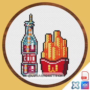 May include: Cross-stitch design featuring a pixelated soda bottle and a container of fries. The bottle is blue, pink, and yellow, and the fries are orange and yellow. The design is in a round wooden frame. The text "@LUNARFOXSTITCH" is at the bottom.