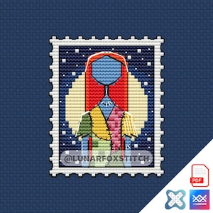 Op de afbeelding: Een kruissteekpatroon in de vorm van een postzegel met een figuur met lang rood haar, een blauw gezicht en een patchworkjurk. De achtergrond is een gele maan tegen een donkerblauwe sterrenhemel. De tekst @LUNARFOXSTITCH is zichtbaar.