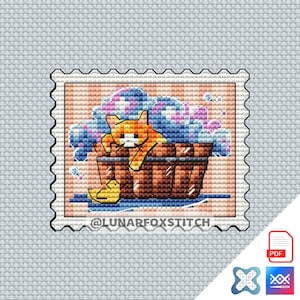 Puede incluir: Un patrón de punto de cruz con un gato en una bañera con burbujas. El patrón está enmarcado en un diseño de sello de correos con el texto "@LUNARFOXSTITCH".