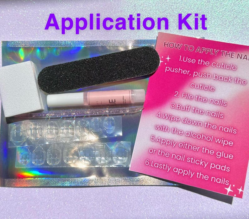 May include: A pink and white instruction card with steps on how to apply press-on nails. The card is next to a clear plastic bag with a nail file, cuticle pusher, glue, and nail adhesive tabs.
