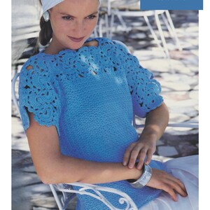 May include: A blue crochet top with a white crocheted neckline and short sleeves. The top is made with a cotton perle yarn and is available in sizes 28 to 42 inches.
