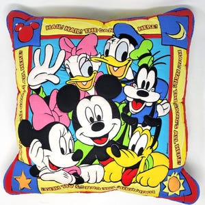 Puede incluir: Cojín cuadrado con Mickey Mouse, Minnie Mouse, Pato Donald, Daisy, Goofy y Pluto. El cojín tiene un centro azul con los personajes y bordes amarillos con el texto "HAIL! HAIL! THE GANG'S ALL HERE!"