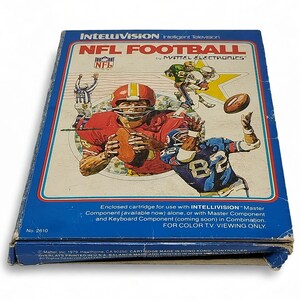 Könnte beinhalten: Ein rechteckiger blauer Pappkarton für das Videospiel NFL Football von Intellivision durch Mattel Electronics. Das Cover zeigt Illustrationen von Footballspielern in Aktion, das NFL-Logo und den Text Intellivision Intelligent Television.
