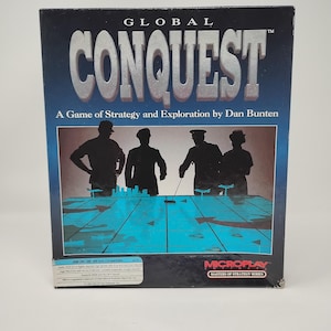 Op de afbeelding: Een rechthoekige videospeldoos voor Global Conquest, een strategie- en verkenningsspel van Dan Bunten. De hoes heeft een donkerblauwe achtergrond met silhouetten van vier figuren rondom een lichtgevende blauwe rasterkaart met pijlen.