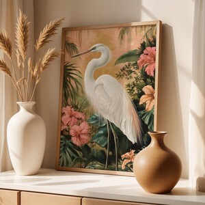 Great egret art print featuring a graceful white heron standing among lush tropical leaves and colourful flowers. Detailed wildlife artwork with elegant composition, perfect for bird lovers and nature enthusiasts. Botanical tropical painting that adds sophistication and serenity to any living room, bedroom, office, or nursery, creating a calming atmosphere. Wildlife inspired wall decor that highlights the beauty of the egret and the harmony of nature through vibrant colours and refined design.
